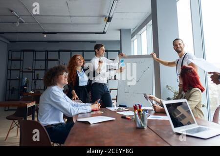 Aufmerksame Zuhörer von jungen kaukasischen Geschäftsmann Rede zu Unternehmen Partner im modernen Büro Stockfoto