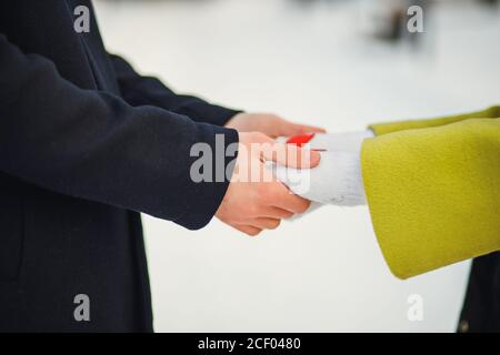 Close-up Hände des Paares in der Liebe, haben Mann und Frau romantische Datum im Winter Straße. Caring Mann halten die Hände der Frau. Liebeskonzept. Im Freien Stockfoto