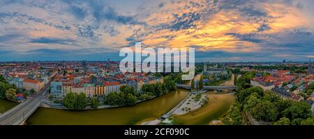 Luftpanorama in München mit der zentral fließenden Isar am luftigen Morgen bei Sonnenaufgang. Stockfoto