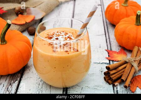 Herbst Kürbis Smoothie mit Kokos und Zimt, Stillleben auf weißem Holz Stockfoto
