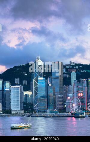 Skyline von Hong Kong Island und Star Ferry bei Sonnenuntergang, Hong Kong Stockfoto