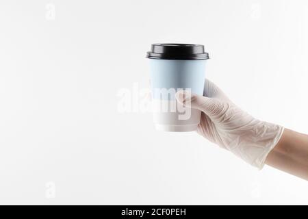 Mockup der menschlichen Hand in weißen Handschuhen halten Take Away Papierbecher für Kaffee oder Tee auf weißem Hintergrund. Copy-Raum. Minimal Kaffee-Konzept. Stockfoto