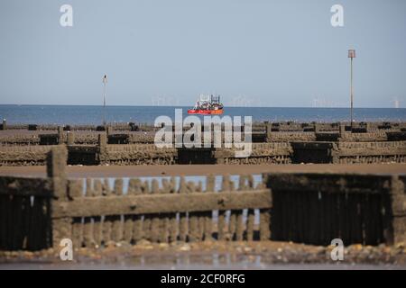 Hunstanton, Großbritannien. September 2020. Ein Fischerboot auf See, wie die Ebbe zeigt See Verteidigung Groynes an einem schönen sonnigen Tag heute in Hunstanton in Norfolk, Großbritannien. Kredit: Paul Marriott/Alamy Live Nachrichten Stockfoto