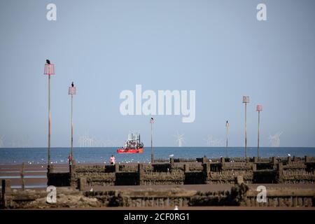 Hunstanton, Großbritannien. September 2020. Ein Fischerboot auf See, wie die Ebbe zeigt See Verteidigung Groynes an einem schönen sonnigen Tag heute in Hunstanton in Norfolk, Großbritannien. Kredit: Paul Marriott/Alamy Live Nachrichten Stockfoto