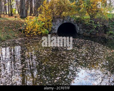 Alte Steinbrücke über kleinen Bach im Herbstwald Stockfoto