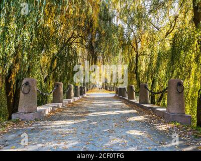 Wunderschöne Brücke und Fußgängerweg durch den herbstlichen öffentlichen Park Stockfoto