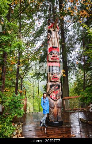 Vancouver Tourist Frau posiert von Totem Pole, British Columbia, Kanada. Asiatische Mädchen besuchen berühmte beliebte Touristenattraktion im Herbst. Stockfoto