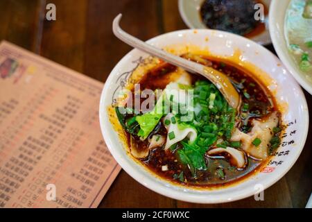 Gekochte Wontons mit würziger Sauce, auch bekannt als Chaoshou, traditioneller Snack in Sichuan, China. Stockfoto