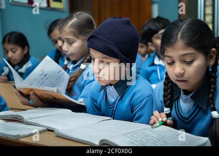 Jodhpur, Rajasthan, Indien - 10. Januar 2020: Indische Grundschüler, die im Klassenzimmer studieren, nehmen Prüfung / Test Schreiben in Notebooks. Bildung concep Stockfoto