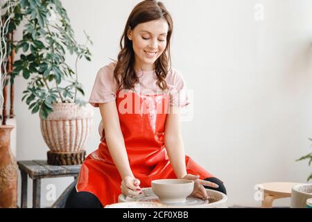 Schöne Töpfer Mädchen macht Keramik zum Braten im Ofen. Konzept Künstlerhandwerk, Konzentration am Arbeitsplatz Stockfoto