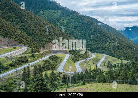 Die kurvenreiche Straße in den Bergen in Tibet. Stockfoto