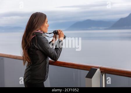 Alaska Kreuzfahrt Frau auf Whale Watching Bootstour mit Ferngläsern, die Tiere betrachten. Tourist in Inside Passage Glacier Bay Ziel auf Stockfoto