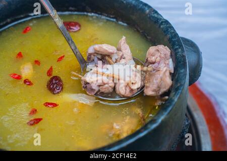 Steintopf Hühnersuppe, ein traditionelles tibetisches Gericht in China. Stockfoto