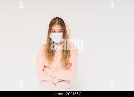 Traurig teen Mädchen in rosa Kapuzenpullover im Gesicht Maske Mädchen In geschlossener Position isoliert auf weißem Hintergrund Stockfoto