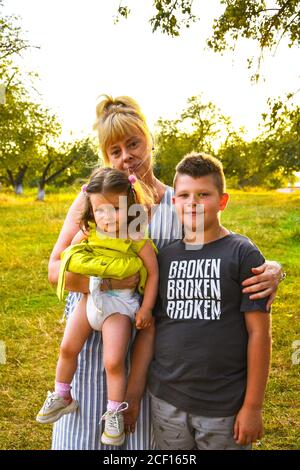 Großmutter mit ihren Enkeln. Enkelin und Enkel im Herbst oder Sommerpark. Familienporträt im Freien. Stockfoto