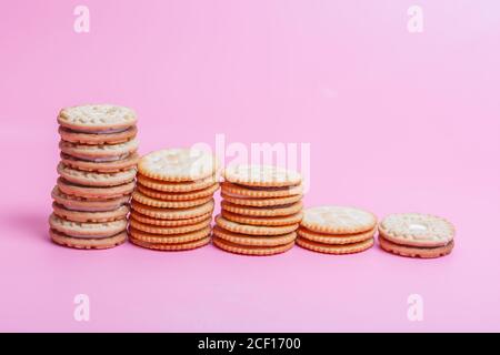 Cremefarbene Sandwich-Kekse auf rosa Hintergrund Stockfoto