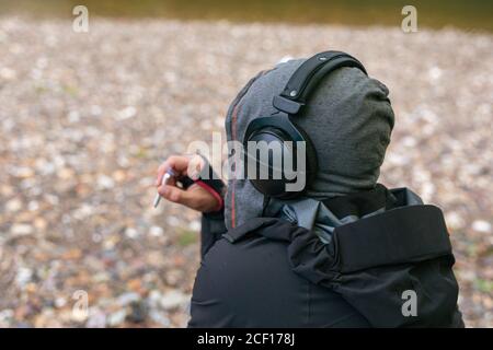 Junge schöne Hipster Mann entspannen Rauchen Zigarette und genießen Sie Musik im Strand hören. Freiheit Konzept. Kopierbereich. Stockfoto