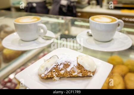 Zwei Tassen Cappuccino und frische Ricotta Cannoli Dessert Nahaufnahme in der Kaffeebar in Sizilien, Italien. Stockfoto