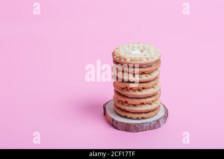 Cremefarbene Sandwich-Kekse auf rosa Hintergrund Stockfoto