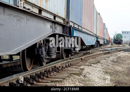 Güterwagen mit Radsatzknoten Nahaufnahme mit den Tanks eines anderen Zuges in der Ferne. Hintergrund. Stockfoto