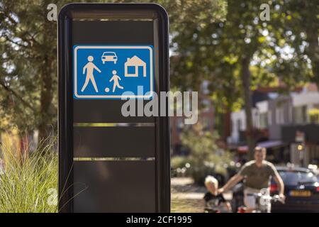 ALMELO, NIEDERLANDE - 02. Aug 2020: Holländisches Verkehrsschild bedeutet, dass Sie in ein Wohngebiet mit Vater und Sohn außerhalb des Fokus im Hintergrund eintreten Stockfoto