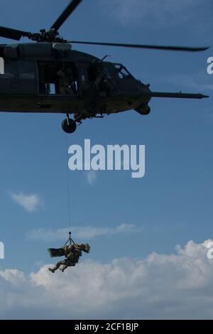 TORII STATION, Japan – EIN Green Beret mit 1. Bataillon, 1. Special Forces Group (Airborne), wird von einer US Air Force HH-60 Pave Hawk Helikopter-Besatzung, die während eines medizinischen Evakuierungstrainings am 19. August 2020 an der Torii Station, Präfektur Okinawa, Japan, eingesetzt wurde, mit einem simulierten Opfer gehisst. Soldaten der Spezialeinheiten führen häufig MEDEVAC-Schulungen durch, um sicherzustellen, dass sie bereit sind, Verwundete im Falle von realen Einsatzszenarien schnell in nachfolgende medizinische Einrichtungen zu transportieren. (USA Armee Foto von Sgt. Anthony Bryant) Stockfoto