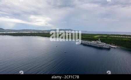 APRA HARBOUR, Guam (24. August 2020) eine Luftaufnahme des US Naval Base Guam (NBG) zeigt den Flugzeugträger USS Ronald Reagan (CVN 76), der im Hafen von Apra festgemacht ist. NBG dient derzeit als sicherer Hafen Freiheitshafen für US-Schiffe und alliierte Marine inmitten der COVID-19 Pandemie. Ronald Reagan, das Flaggschiff der Carrier Strike Group 5, bietet eine kampfbereite Kraft, die die Vereinigten Staaten schützt und verteidigt, sowie die kollektiven maritimen Interessen ihrer Verbündeten und Partner in der Indo-Pazifik-Region. (USA Navy Foto von Mass Communication Specialist 3rd Class MacAdam Kane Weissman) Stockfoto