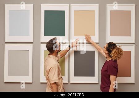 Junges Paar zeigt auf Bild hängen an der Wand, während Sie besuchen die Kunstgalerie Stockfoto