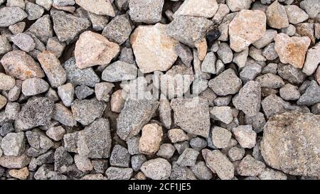 Hintergrund von Steinen. Steinhaufen. Loft-Stil im Inneren, Grunge. Die alten Steine. Um die Asphaltstraße zu tun. Stockfoto