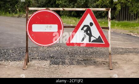 Straßenschild auf der Straße. Schild für die Arbeitsreparatur. Reparatur von Straßen. Um Asphalt zu machen. Straße vor geschlossen und Umleitung Zeichen in einer Straße während der Bauarbeiten. Stockfoto