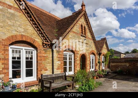 Die Exerzitien, eine Terrasse von historischen Armenhäuser stammt aus dem Jahr 1892, in einem Hinterhof an der High Street, Stony Stratford, UK eingestellt Stockfoto