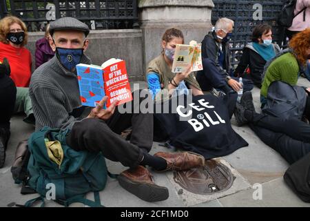 Protestler von Extinction Rebellion inszenieren einen Sitzprotest vor dem Houses of Parliament, London. Die Umweltkampagnengruppe hat Veranstaltungen geplant, die an mehreren Sehenswürdigkeiten der Hauptstadt stattfinden sollen. Stockfoto
