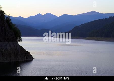 Rumänien, Karpaten, Hügel über dem See bei Sonnenuntergang. Rumänien, Karpaten, Hügel über dem See bei Sonnenuntergang. Wzgórza o zachodzie słońca. Stockfoto