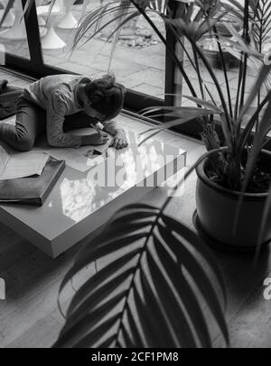 Junge macht Hausaufgaben auf Couchtisch Stockfoto