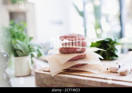 Nahaufnahme roher Hamburger-Patties auf Schneidebrett gestapelt Stockfoto