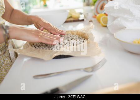 Frau blind Backen Tortenkruste mit Kuchen Gewichte in der Küche Zähler Stockfoto