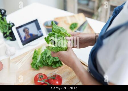 Frau Kochen und Video-Chat mit digitalen Tablet in der Küche Stockfoto