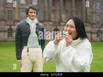 REDAKTIONELLE VERWENDUNG NUR Kuchen-Designerin Michelle Wibowo mit ihrem lebensgroßen Kuchen von Herrn Darcy, wie von Colin Firth in der TV-Mini-Serie von Stolz und Vorurteil gespielt, die im National Trust Eigentum Lyme Park in Disley enthüllt wurde, Cheshire. Stockfoto