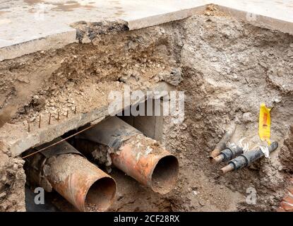 Städtisch, Infrastruktur, Austausch von Rohrleitungen, Straßenarbeiten, Querschnitt, Graben von Straßen in der Stadt, Schichten, Asphalt, Kies, Ton, Sand, Aushub, Rohrleitungen Stockfoto