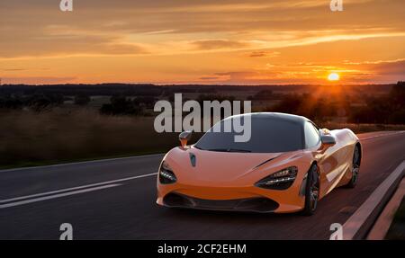 McLaren 720S vor dem Hintergrund eines wunderschönen Abendhimmels Beim schnellen Fahren Stockfoto