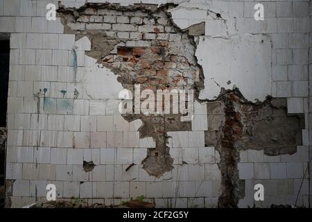 Hintergrund der alten Wand mit bröckelnden Fliesen. Rost und Streifen, Ruine Stockfoto