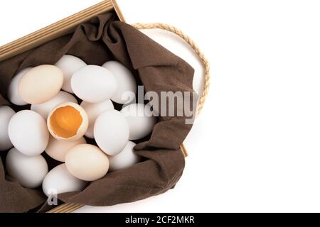 Die Eier sind weiß und braun mit einem zerbrochenen Ei in der Mitte, in dem ein frisches Eigelb sichtbar ist. Stockfoto