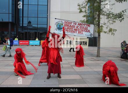 Cardiff, Wales, Großbritannien. September 2020. Extinction Rebellion Protestierende vor der BBC am dritten Aktionstag in Cardiff, 3. September 2020. Demonstranten fordern die BBC auf, die Wahrheit zu sagen und die Rote Rebellenbrigade posiert vor der BBC zusammen mit zweisprachigen Transparenten Credit: Denise Laura Baker/Alamy Live News Stockfoto