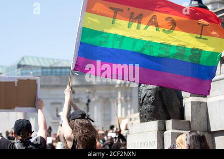 Ein Protestant von Black Lives Matter winkt bei einem Protest auf dem Trafalgar Square in London eine Regenbogenfahne mit der Aufschrift "Ich kann nicht atmen" Stockfoto