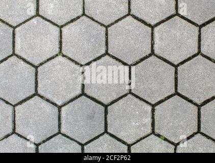 Straße gepflastert mit sechseckigen Bürgersteig Fliesen. Schöne Backstein-Hintergrund mit, Mauerwerk Textur von hellgrauen Ziegel. Im Freien Nahaufnahme Stockfoto