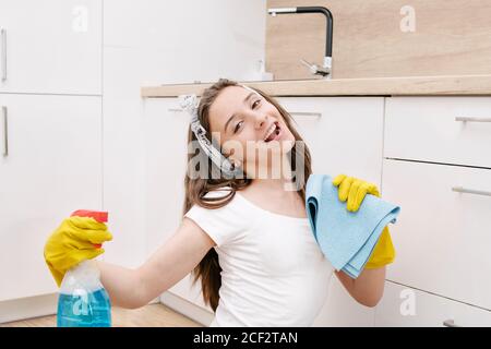 Junges Mädchen reinigt die Wohnung. Müde Mädchen nach der Reinigung sitzt auf dem Boden mit einem Staubsauger und spricht am Telefon. Stockfoto