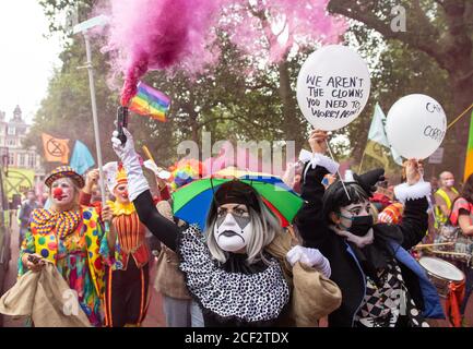 Extinction Rebellion Protestierenden gekleidet als Clowns vor dem HM Treasury Gebäude während einer Extinction Rebellion Protest in Westminster, London. Die Umweltkampagnengruppe hat Veranstaltungen geplant, die an mehreren Sehenswürdigkeiten der Hauptstadt stattfinden sollen. Stockfoto