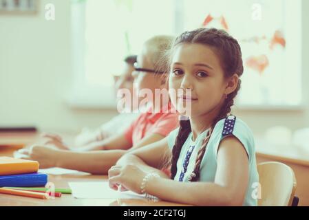 Portrait von ziemlich hispanischen Kind Mädchen Studing im Klassenzimmer während Eine Lektion in der Grundschule Stockfoto