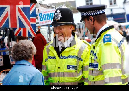 Polizist und Community Support Officer unterhalten sich mit einer älteren Frau auf dem lokalen Markt; Knaresborough; Scarborough; Yorkshire UK Stockfoto