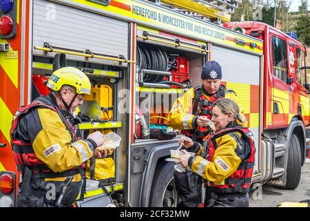 Bewdley Floods, Februar 2020. Hereford und Worcester Feuerwehr und Rettungsdienst nehmen willkommene Pause während der geschäftigen Schicht, Essen im Freien mit Feuerwehrmotor. Stockfoto